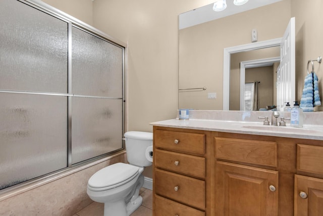 bathroom featuring combined bath / shower with glass door, vanity, toilet, and tile patterned floors