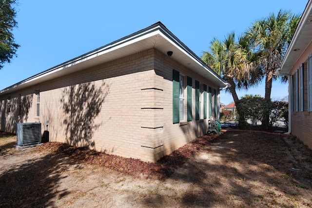 view of side of property with brick siding and cooling unit