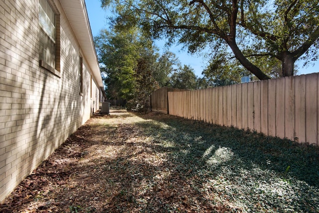 view of yard featuring central air condition unit and fence