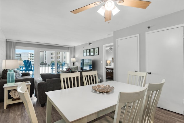 dining space with ceiling fan and dark hardwood / wood-style flooring