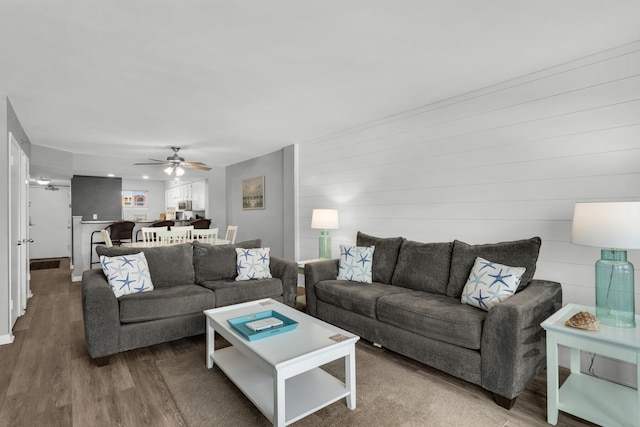 living room featuring wood-type flooring and ceiling fan