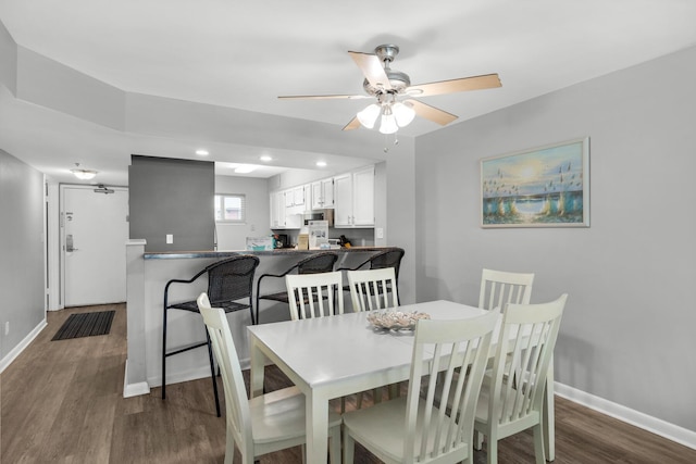 dining room with ceiling fan and dark hardwood / wood-style flooring