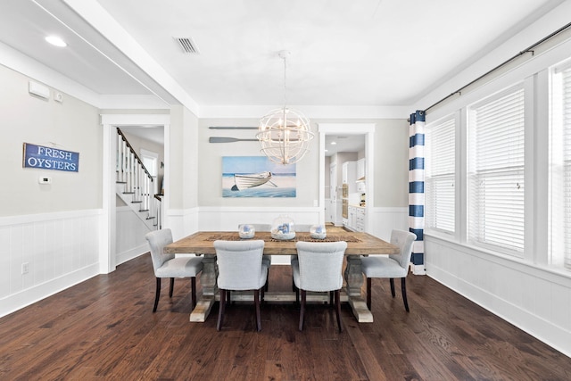 dining space featuring wainscoting, visible vents, dark wood finished floors, and stairs