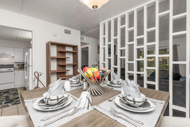 tiled dining room featuring a textured ceiling