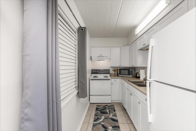 kitchen featuring white appliances, light tile patterned floors, white cabinets, and a textured ceiling