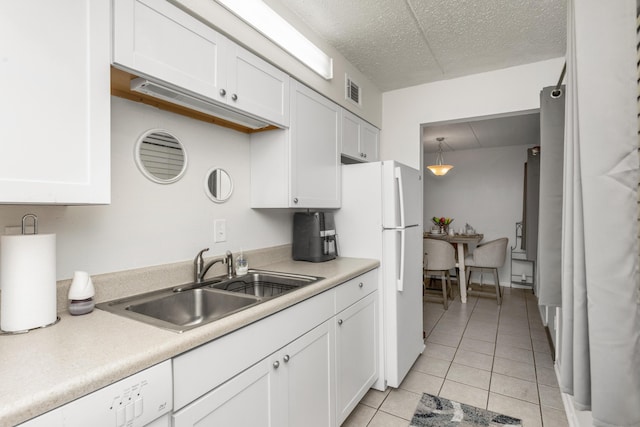 kitchen with white appliances, sink, white cabinets, and decorative light fixtures