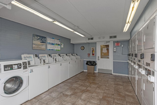 laundry area featuring stacked washing maching and dryer, brick wall, and separate washer and dryer