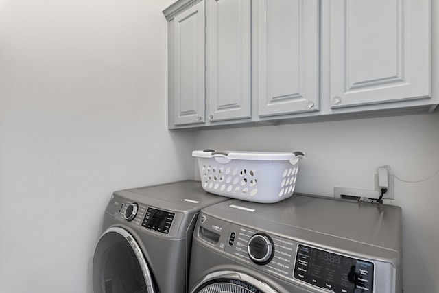 washroom with cabinets and independent washer and dryer