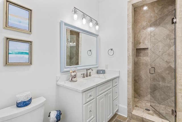 bathroom with walk in shower, vanity, and toilet