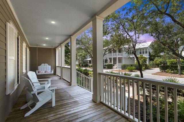 deck at dusk featuring a porch