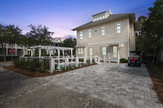 back house at dusk with a pergola