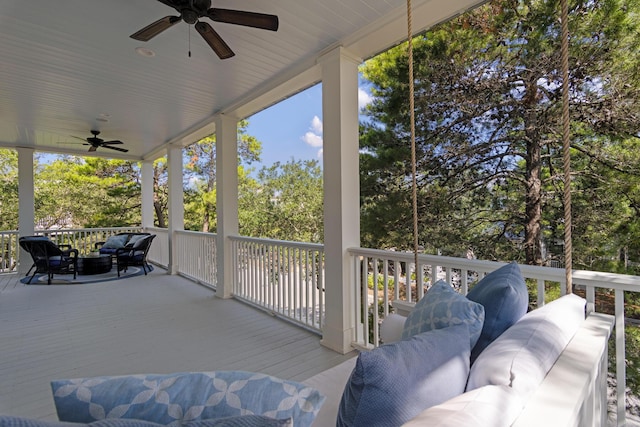 wooden terrace with ceiling fan and an outdoor hangout area