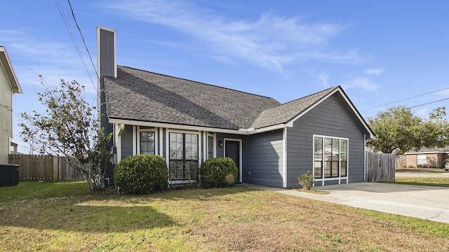 view of front of home with central AC and a front lawn