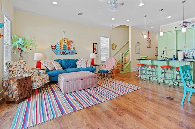 living room with light hardwood / wood-style floors and crown molding
