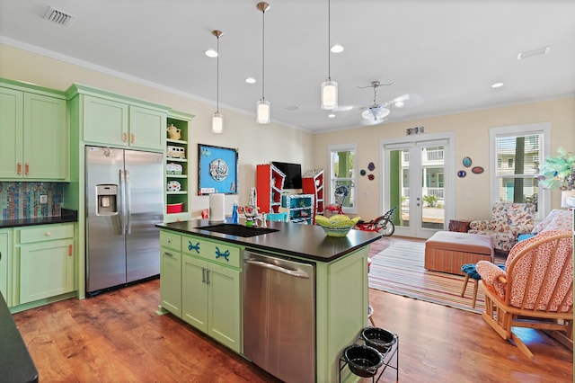 kitchen featuring green cabinetry, french doors, a kitchen island, and stainless steel appliances