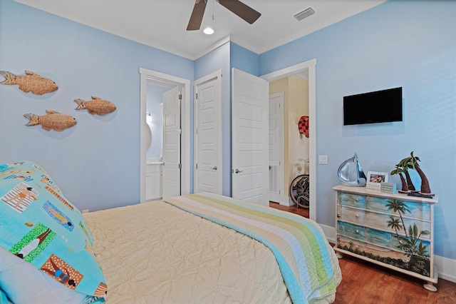 bedroom featuring ornamental molding, connected bathroom, dark hardwood / wood-style floors, and ceiling fan