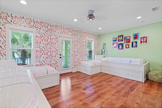 bedroom with ceiling fan, access to outside, and wood-type flooring