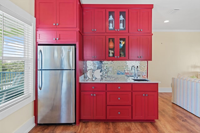kitchen featuring sink, stainless steel refrigerator, tasteful backsplash, and wood-type flooring