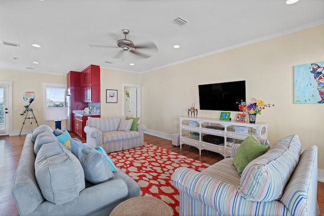 living room featuring ceiling fan, dark wood-type flooring, and crown molding