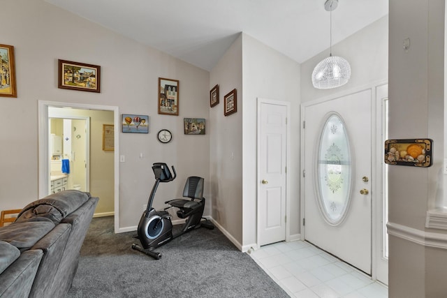 foyer entrance featuring vaulted ceiling, light colored carpet, and baseboards