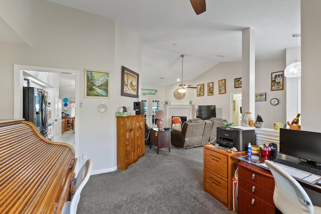 home office with baseboards, a ceiling fan, light colored carpet, lofted ceiling, and a fireplace