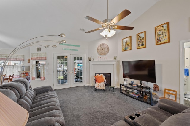 carpeted living room with a wealth of natural light, french doors, a fireplace, and vaulted ceiling