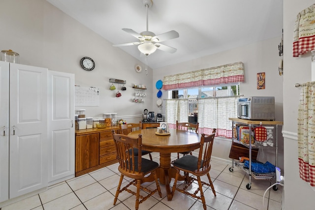 dining room with vaulted ceiling, ceiling fan, light tile patterned flooring, and a toaster