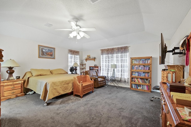 bedroom featuring ceiling fan, visible vents, dark colored carpet, and a textured ceiling