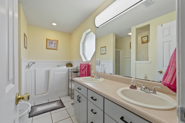 full bathroom featuring double vanity, visible vents, a sink, and tile patterned floors