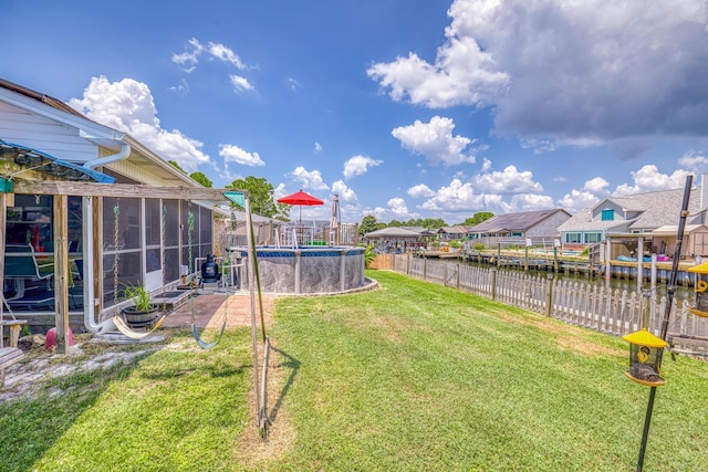 view of yard featuring a fenced in pool, a residential view, a water view, and a fenced backyard