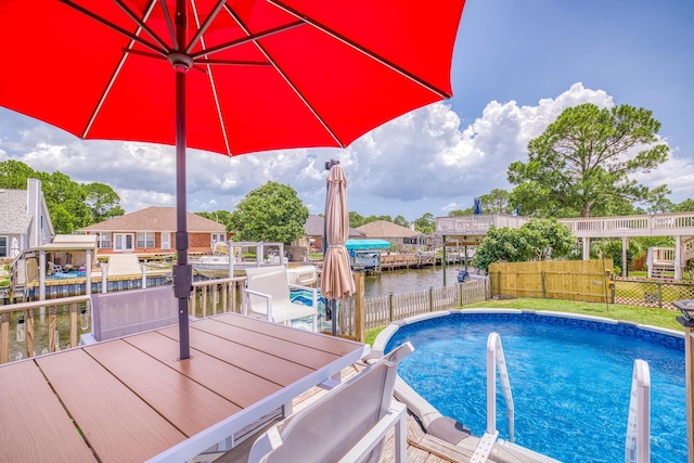 view of swimming pool with a water view, fence, and a fenced in pool