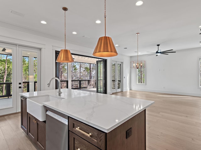 kitchen with french doors, sink, decorative light fixtures, stainless steel dishwasher, and light hardwood / wood-style floors