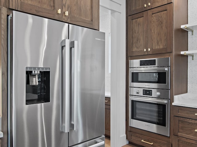 kitchen featuring dark brown cabinetry and appliances with stainless steel finishes