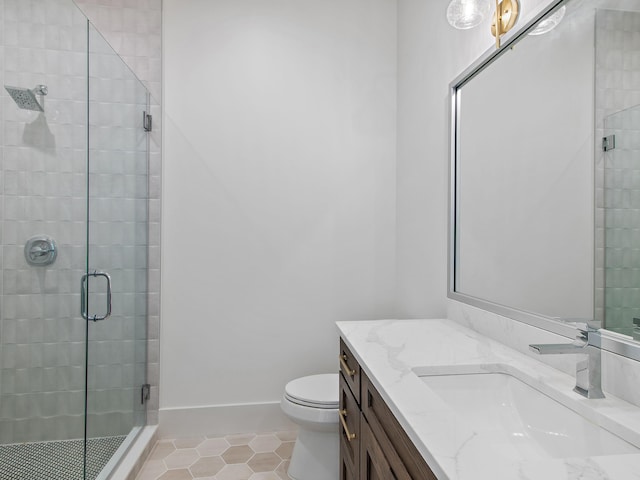 bathroom with vanity, a shower with shower door, tile patterned floors, and toilet