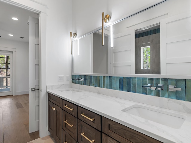 bathroom featuring hardwood / wood-style flooring, tasteful backsplash, plenty of natural light, and vanity