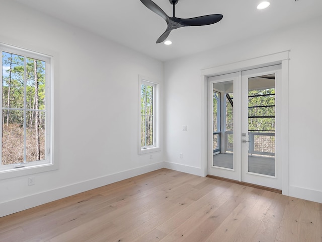 empty room with french doors, ceiling fan, and light hardwood / wood-style floors