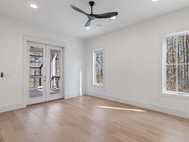 empty room featuring french doors, ceiling fan, plenty of natural light, and light wood-type flooring