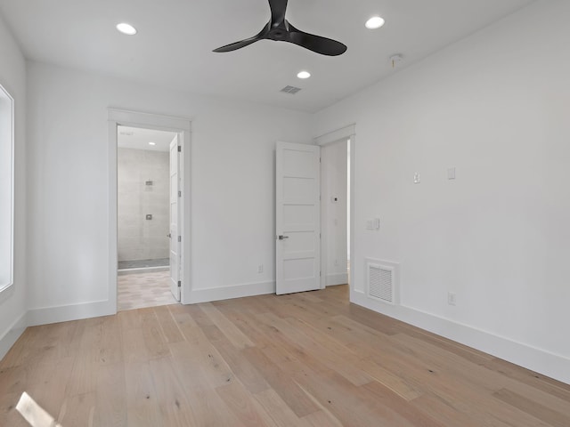 unfurnished bedroom featuring ceiling fan, ensuite bath, and light wood-type flooring