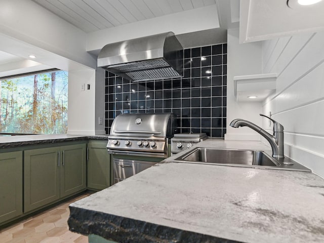 kitchen featuring sink, extractor fan, green cabinetry, light stone countertops, and backsplash