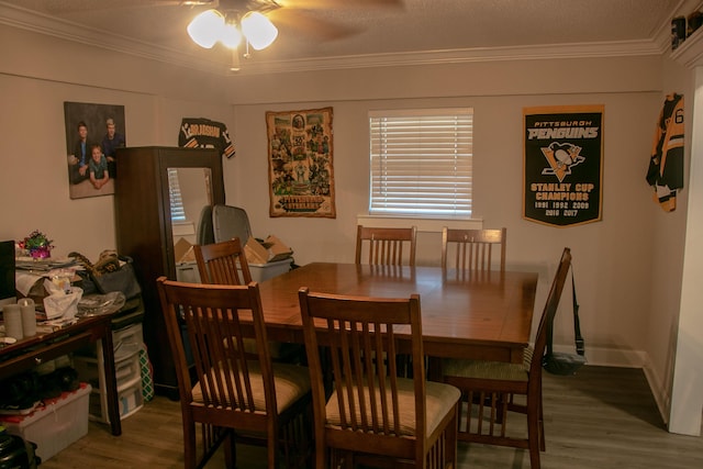 dining room with wood-type flooring, ornamental molding, and ceiling fan