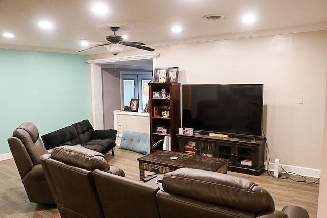 living room featuring ceiling fan, ornamental molding, and light wood-type flooring