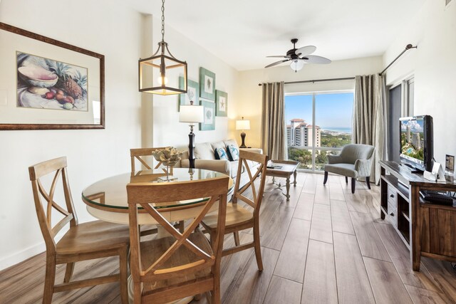 dining space with hardwood / wood-style flooring and ceiling fan