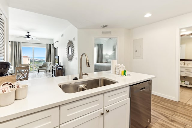 kitchen featuring dishwashing machine, sink, light hardwood / wood-style flooring, white cabinetry, and electric panel