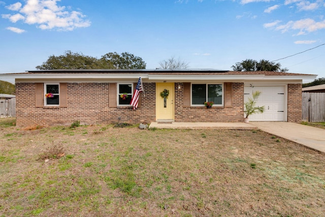 ranch-style house with a garage, solar panels, concrete driveway, a front yard, and brick siding