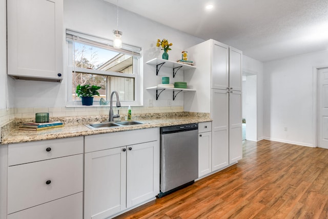 kitchen with light wood-style flooring, a sink, white cabinets, stainless steel dishwasher, and open shelves