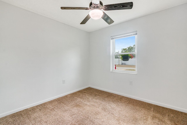 carpeted spare room with ceiling fan and baseboards