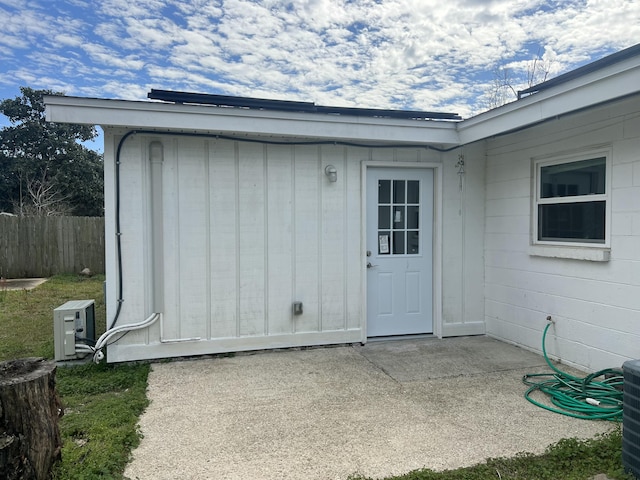 entrance to property featuring a patio and fence