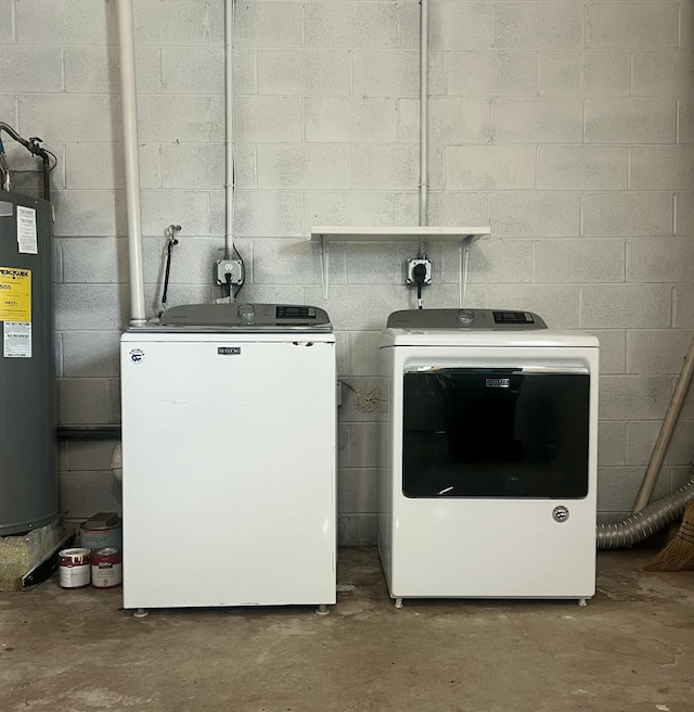 laundry room with concrete block wall, laundry area, water heater, and independent washer and dryer