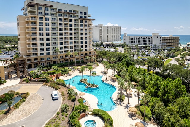 view of pool with a water view and a patio area