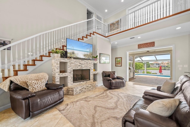 503 Regatta Bay Blvd, Destin, FL 32541 - living area featuring crown molding, a towering ceiling, tile patterned flooring, stairway, and a fireplace